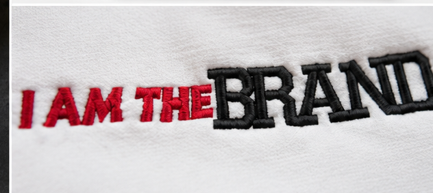 Close-up of I AM THE BRAND pink and black embroidery